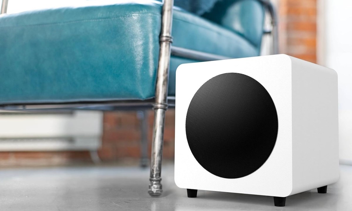 The Kanto Sub8 in Matte White set up next to a chair.